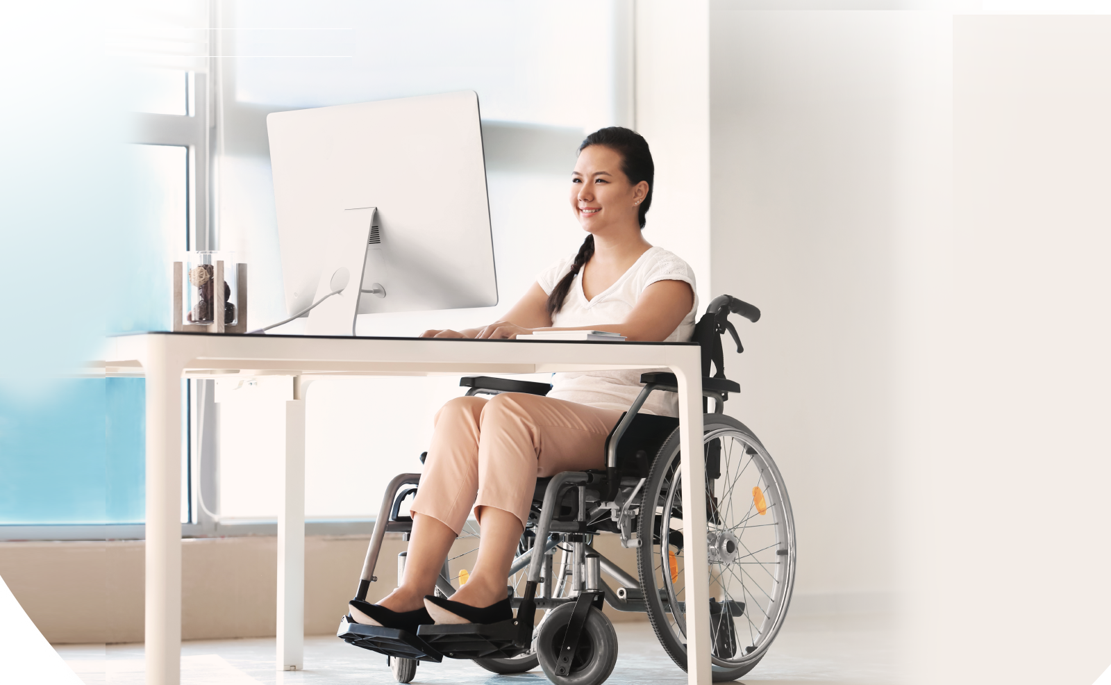 Illustrative image of a person on wheelchair looking at a computer screen